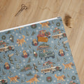 Christmas Convoy Wrapping Paper — unrolled on the table with scissors, twine and a gift tag