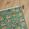 Holiday Rounds Wrapping Paper — unrolled on the table with scissors, twine and a gift tag