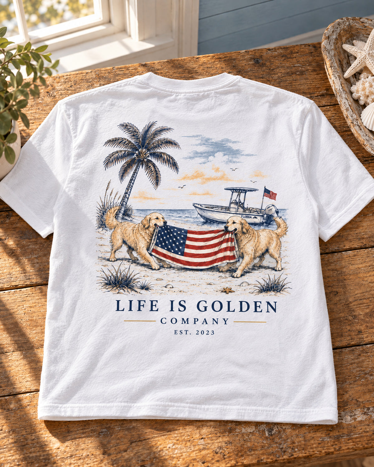 White Red White and English Cream tee folded flat on a horizontal wooden table, with the full back illustration and lettering visible.