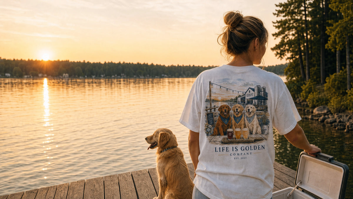 a quiet lakeside dock at amber dusk, she walks toward an open cooler while her golden retriever waits beside the water