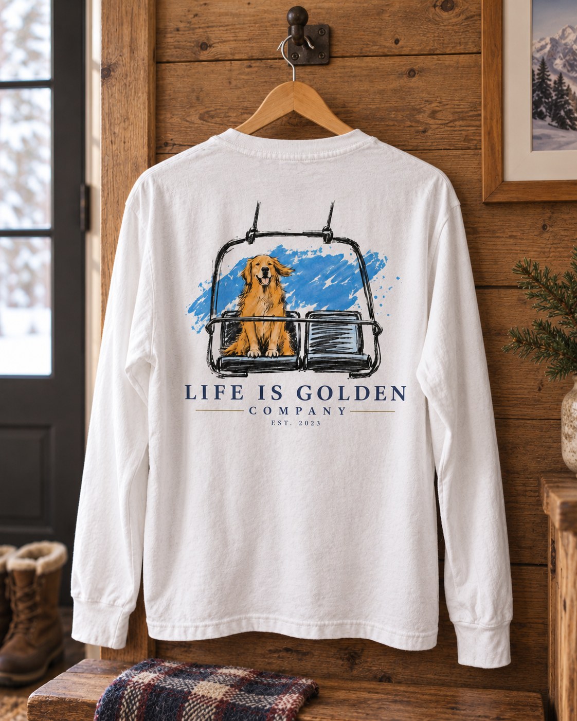 White One More Lap long-sleeve shirt naturally hanging from a visible wooden hanger and wall hook, showing the complete back illustration.